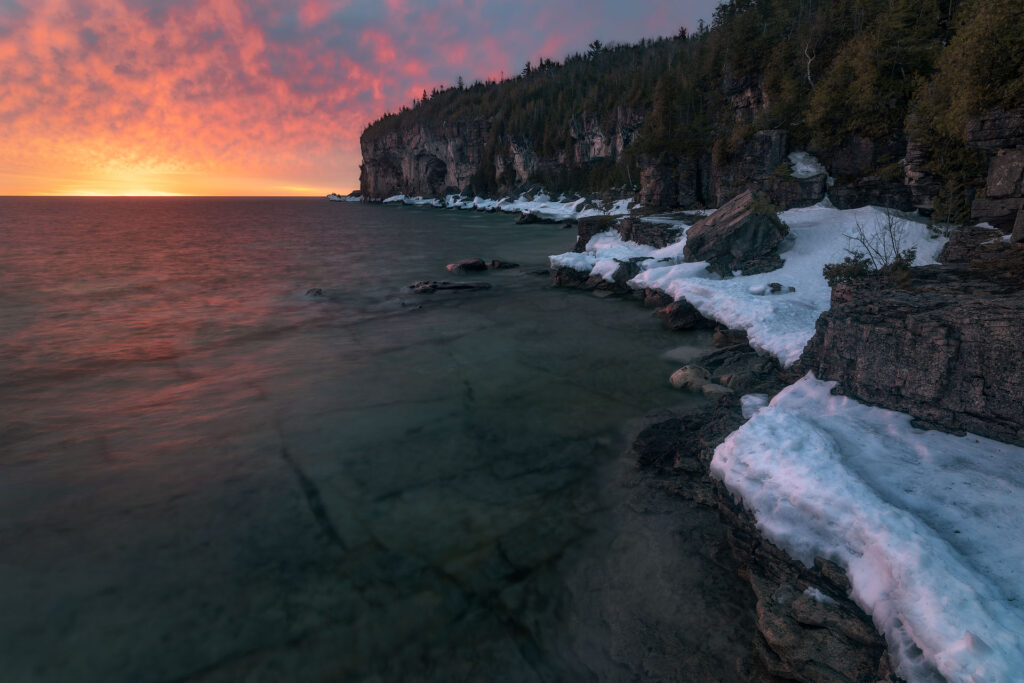 burning sunrise over lake cliffs