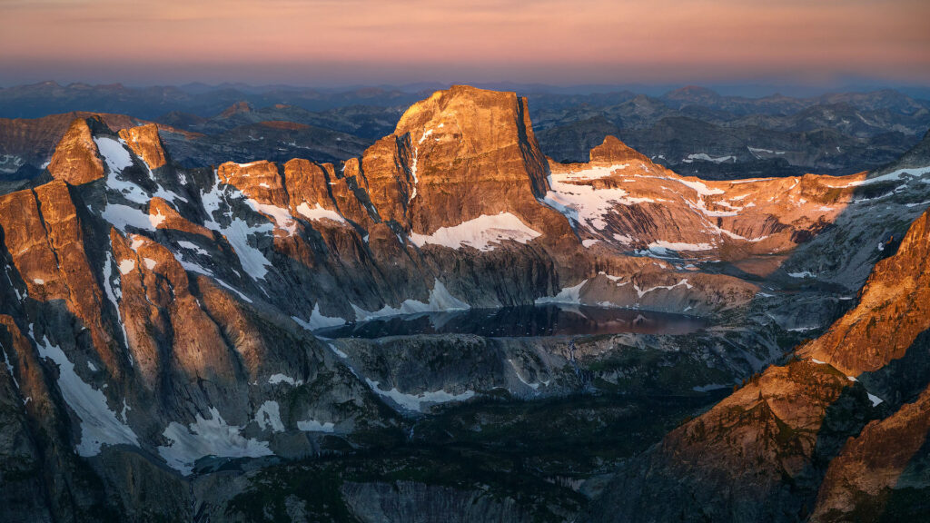 mountain walls sheltering an alpine lake in sunrise light