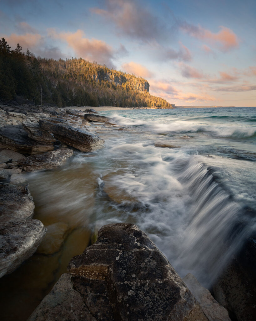 Waves flow over rocks on shoreline under cliff faces of Bruce Peninsula National Park