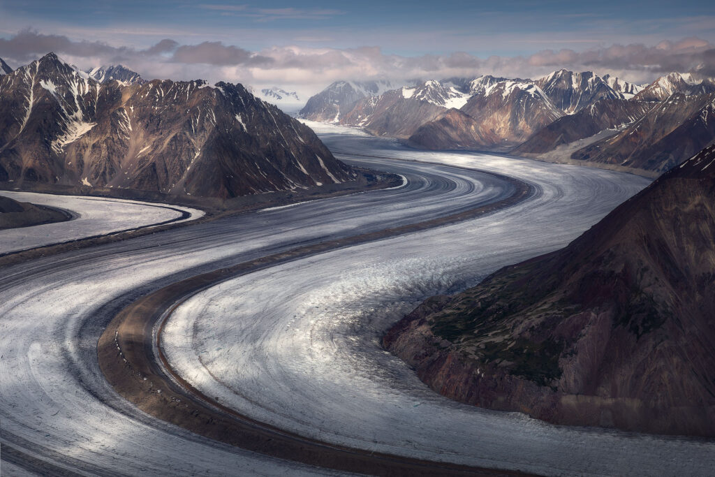 enormous glacier moving through mountains