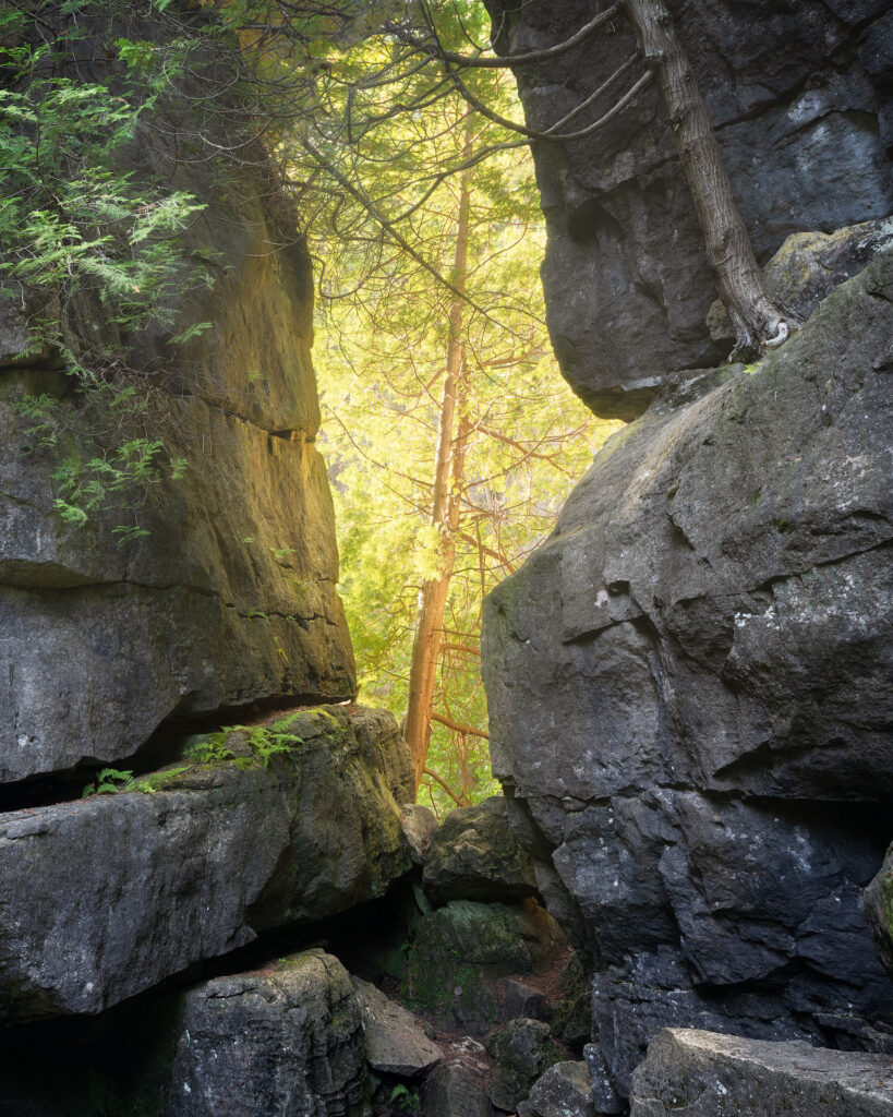 light breaks through a small crack in a rock face