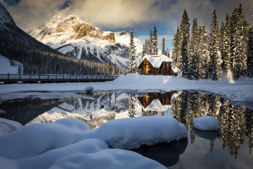 Emerald lake lodge in front of a snowy mountain backdrop deep within the Canadian Rockies and Yoho National Park.