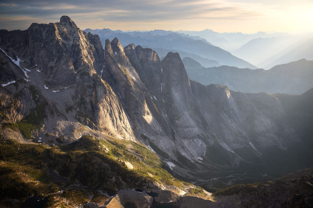 misty sunrise over repeating mountain peaks and valleys