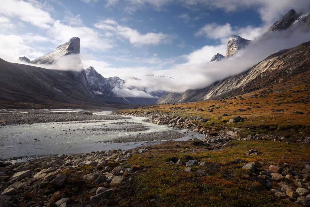 ancient arctic peaks over flying geese and roaring river