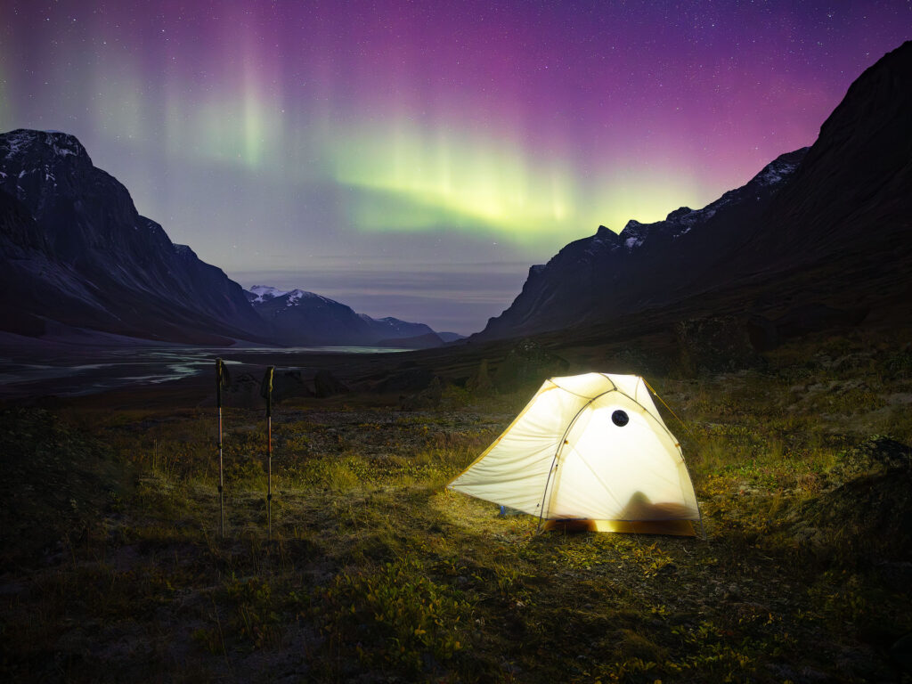 Tent under glowing aurora in the Arctic